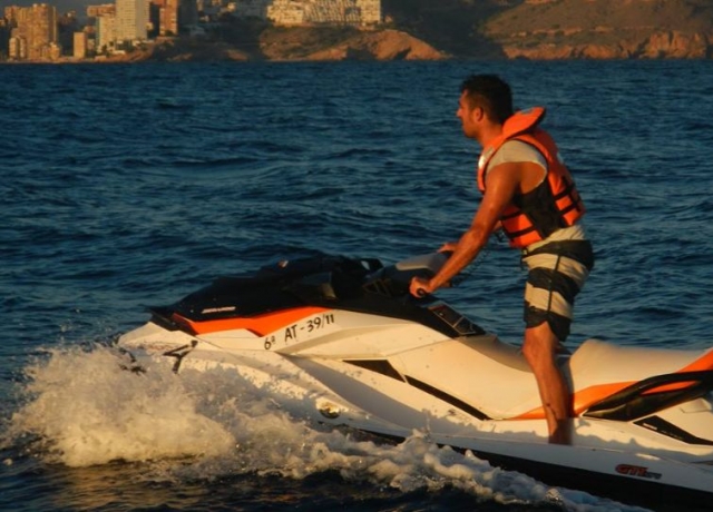  站在摩托艇上，背景是贝尼多姆 